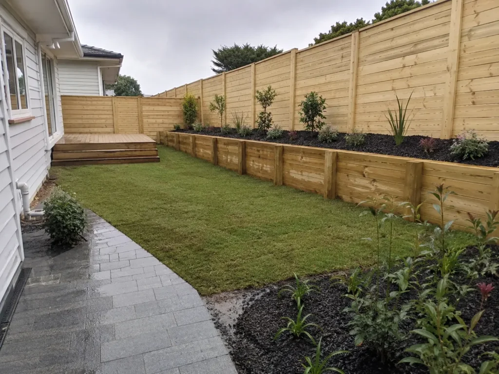 Representative Auckland landscaping with fencing, decking, retaining wall, paving, planting and lawn